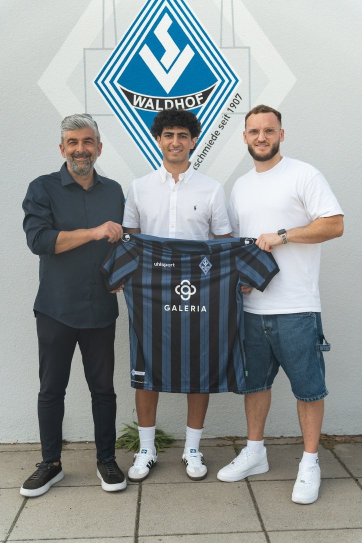 Ahmed Yaqub with his SV Waldhof Mannheim shirt, together with two club representatives